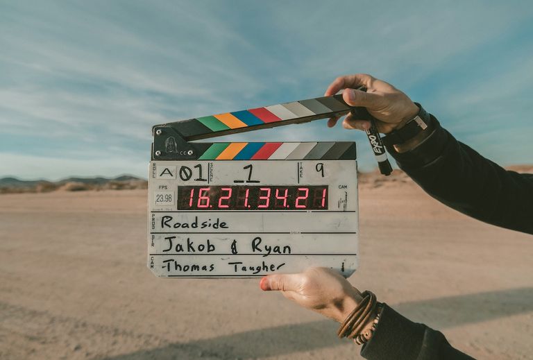 Person holding a movie slate clapboard in a desert shoot for Roadside, directed by Jakob and Ryan, photo by Jakob Owens.